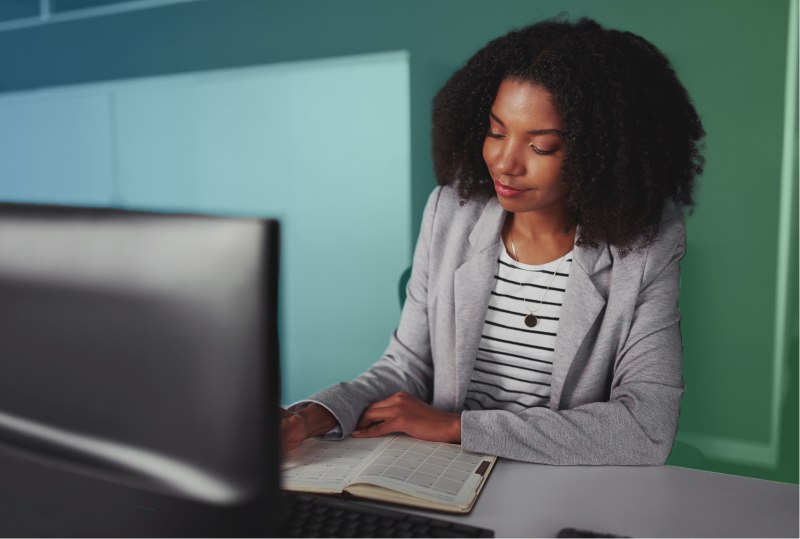 An employee is taking part in their organization's learning and development program, sitting at their desk and taking an online training course.