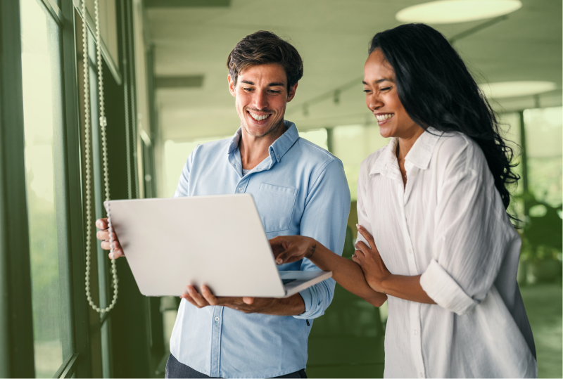 Two employees are reviewing a company policy to ensure it aligns with the Working for Workers Seven Act proposals